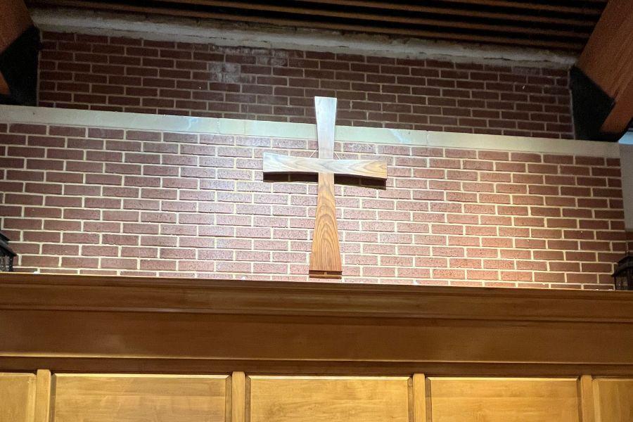 Photo of the Rolf Cross set against a brick background.