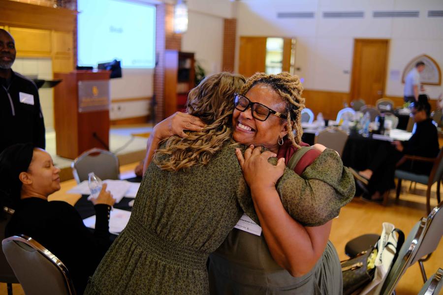 Attendees embracing at Bridge to Belonging event.